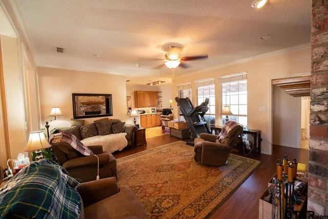 a living room with furniture kitchen view and a wooden floor