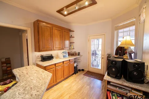 a kitchen with a stove a sink and wooden floor