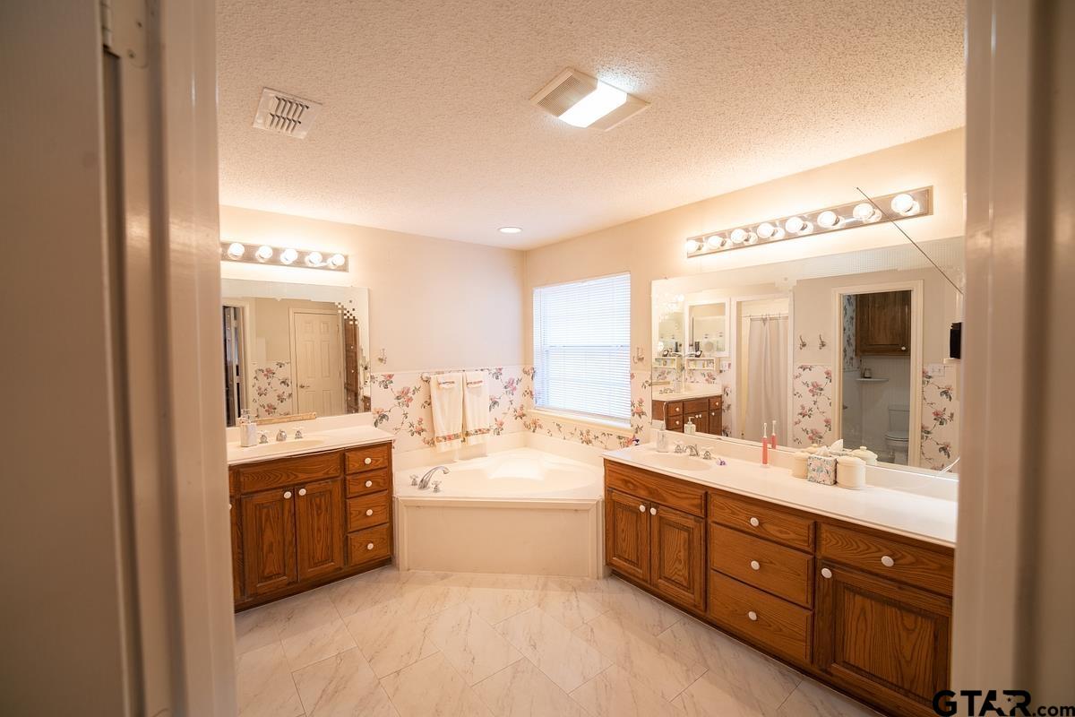 19757-c R 444 C R 444 Lindale, TX 75771 - Photo 20 of 34 a spacious bathroom with a double vanity sink a large mirror and a bathtub