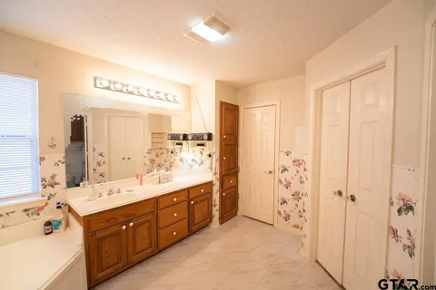 a spacious bathroom with a double vanity sink a mirror and a shower