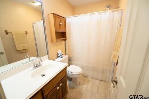 a bathroom with a sink a toilet and shower curtain