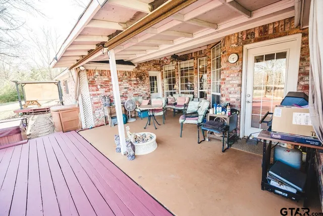 a view of a patio with table and chairs and wooden floor
