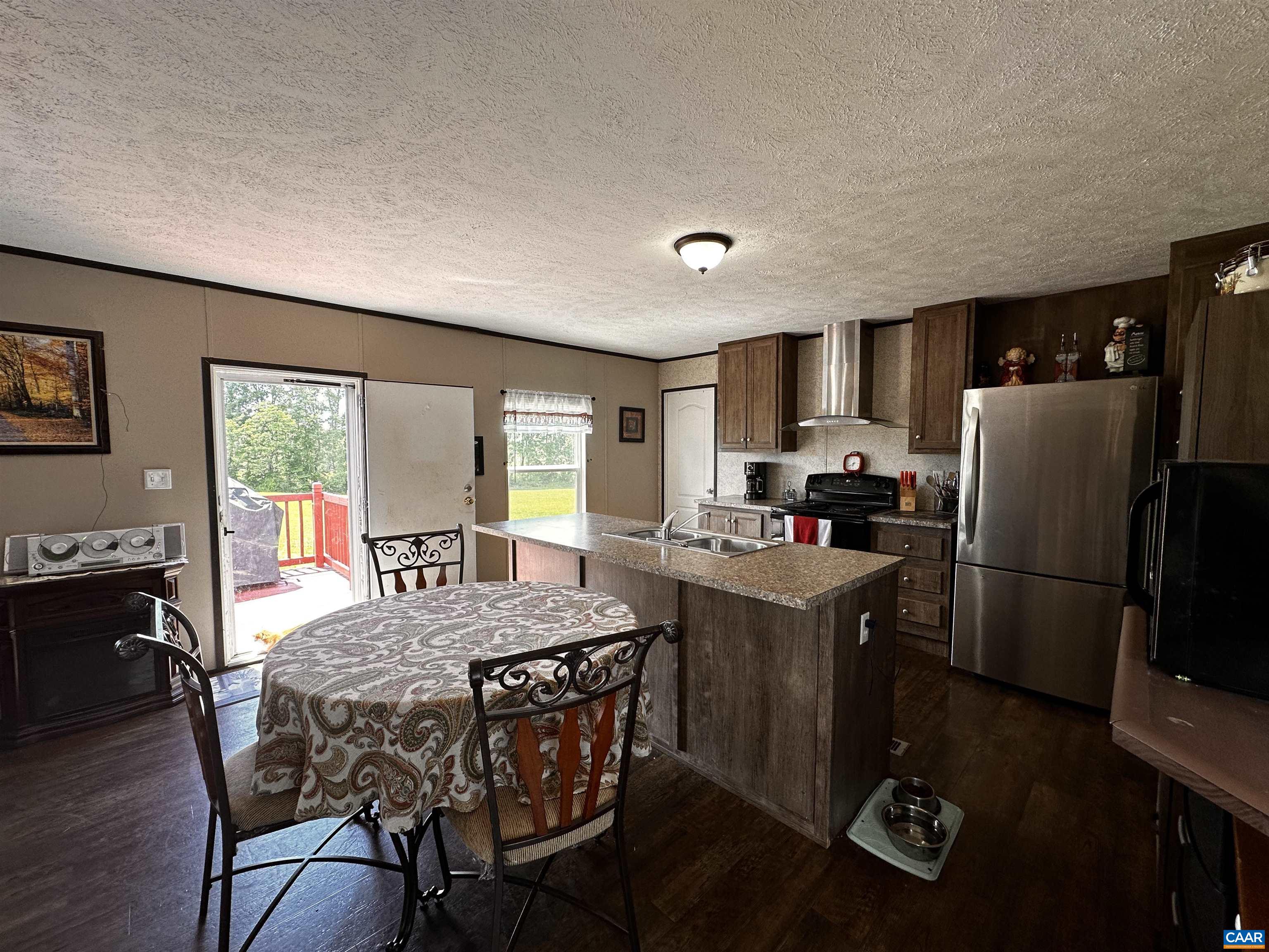 1625 South Constitution Route Dillwyn, VA 23936 - Photo 9 of 30 a kitchen with stainless steel appliances granite countertop a stove a refrigerator a sink dishwasher a dining table and chairs with wooden floor