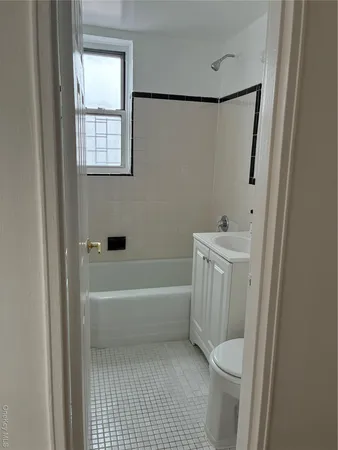 a bathroom with a bathtub a window a shower and a toilet