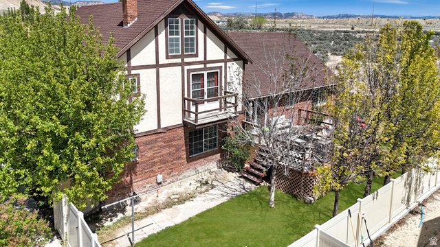 1716 Sagewood Road Price, UT 84501 - Photo 62 of 73 View of property exterior featuring stucco siding, a chimney, a fenced backyard, a mountain view, and a balcony