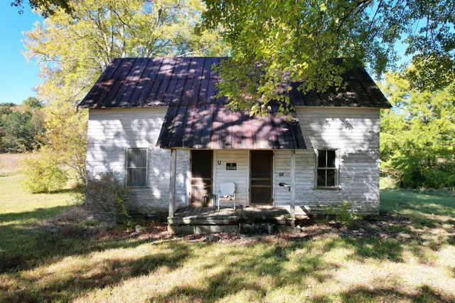 a front view of a house with yard and trees