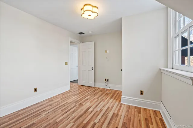 a view of a room with wooden floor and a window