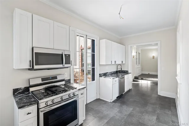 a kitchen with stainless steel appliances a stove a microwave and cabinets