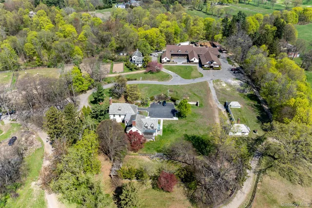 an aerial view of residential houses with outdoor space and trees all around