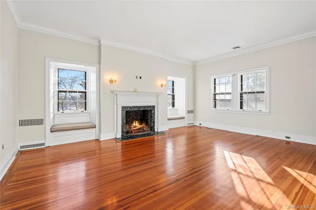 a view of empty room with wooden floor and fireplace