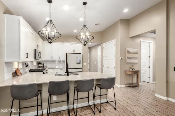 a kitchen with stainless steel appliances kitchen island granite countertop a table and chairs in it