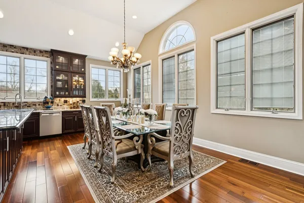 a view of a dining room with furniture a chandelier and wooden floor