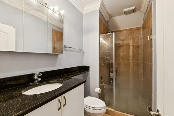 a bathroom with a glass shower door and a toilet