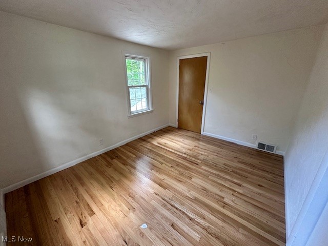 15959 Glynn Road Cleveland, OH 44112 - Photo 17 of 23 Spare room featuring light wood-style flooring and a textured ceiling