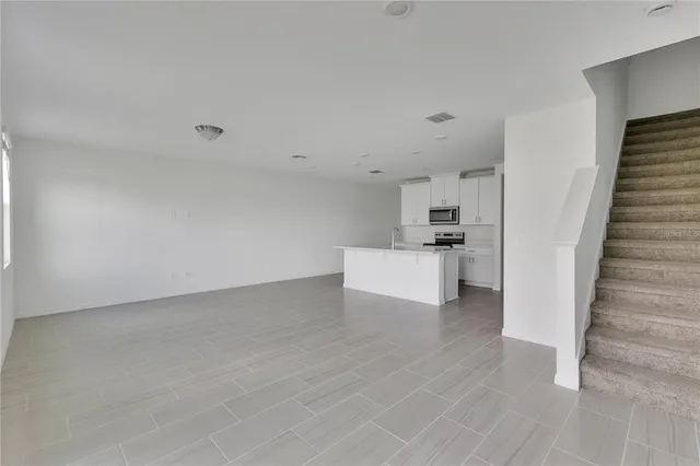 a view of a kitchen with white cabinets and white appliances