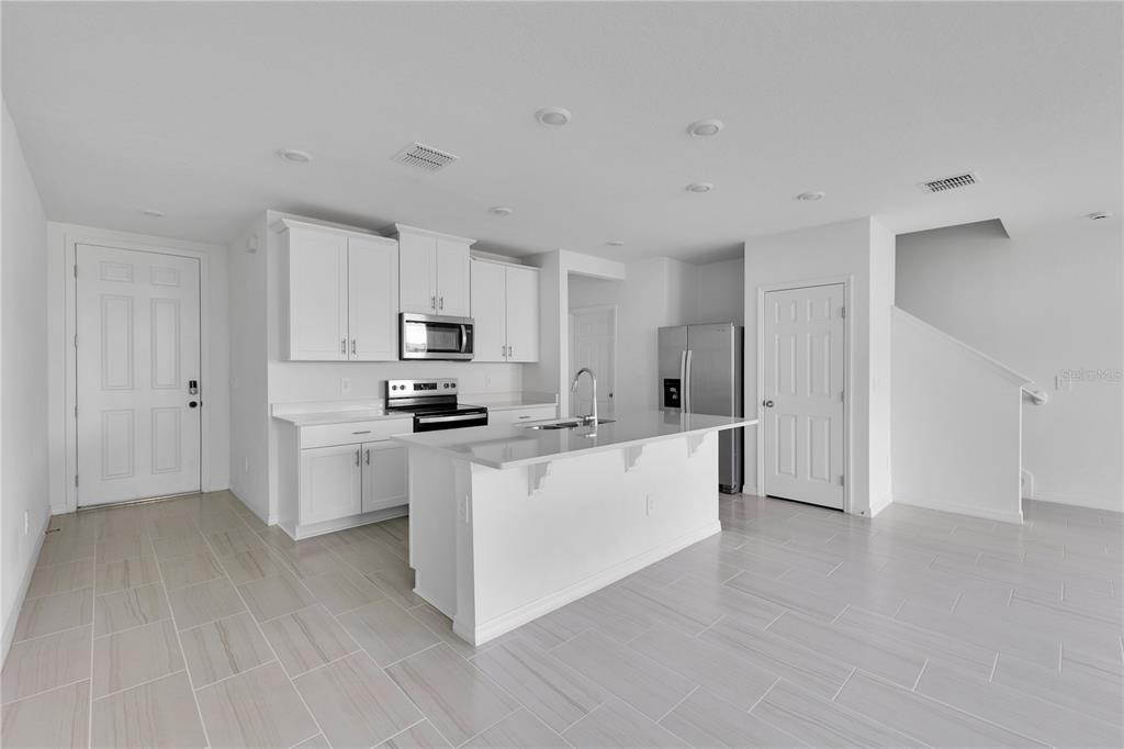 4367 Ranch House Road St. Cloud, FL 34772 - Photo 5 of 29 a kitchen with stainless steel appliances a refrigerator sink and white cabinets
