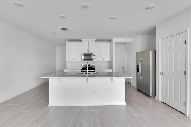 a kitchen with stainless steel appliances a sink a stove a refrigerator and cabinets