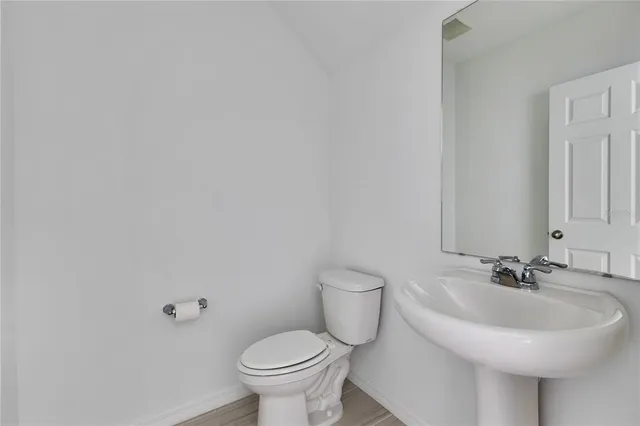 a bathroom with a sink a toilet and mirror