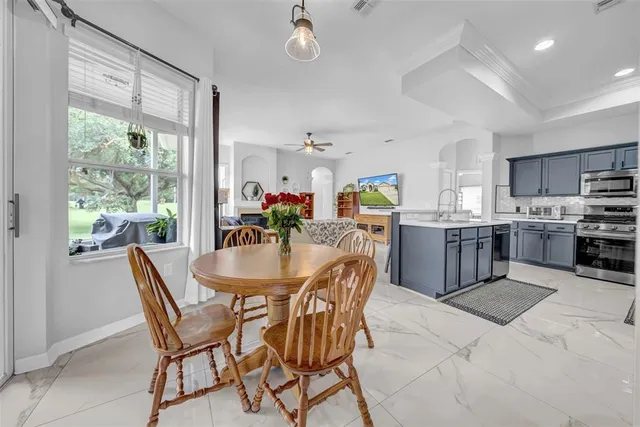 a kitchen with stainless steel appliances granite countertop a stove top oven a sink dishwasher and white cabinets with wooden floor