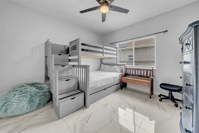 a bedroom with a bed a flat screen tv and a fireplace