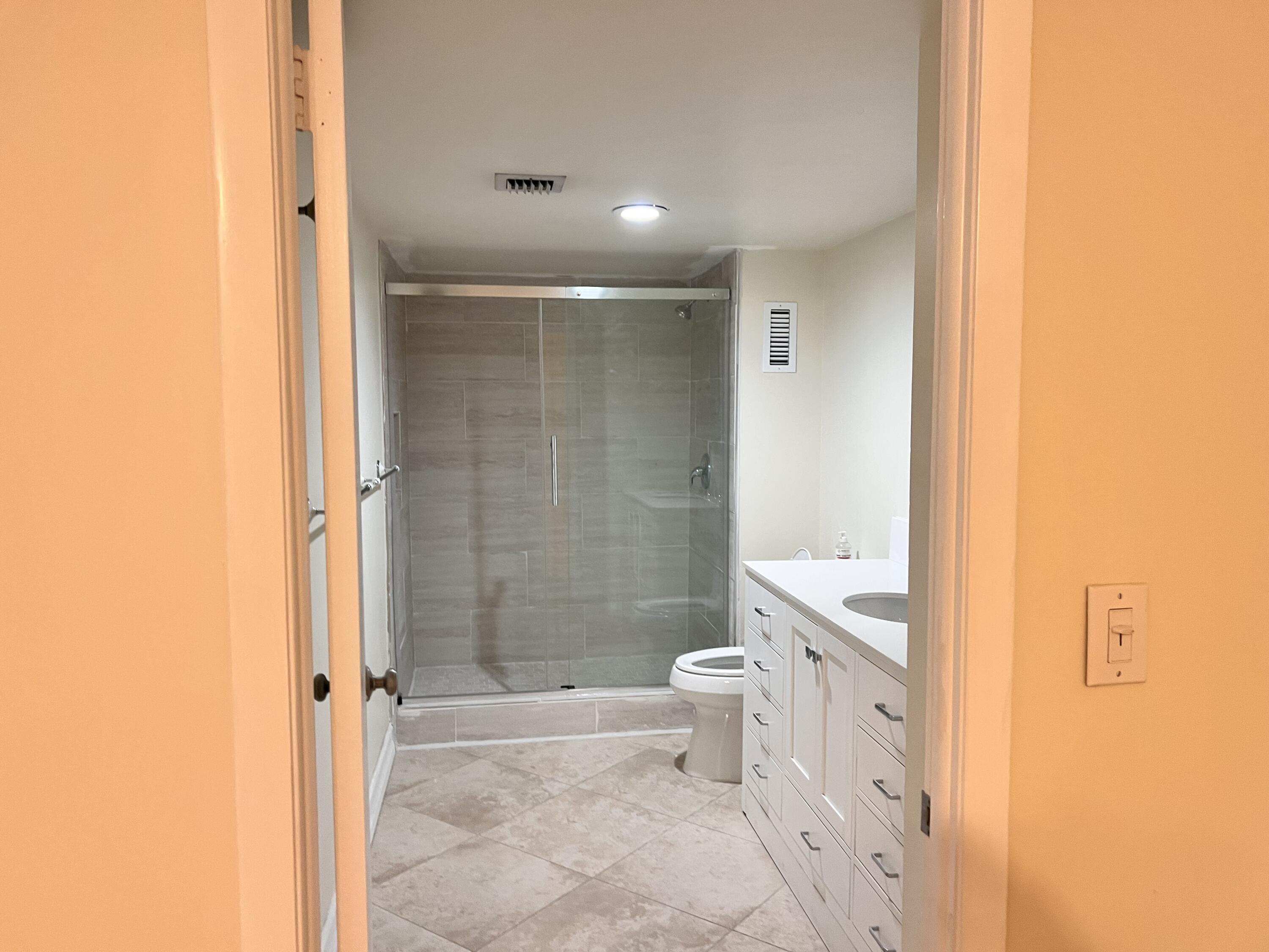 6000 Northwest 2nd Avenue, Unit 439 Boca Raton, FL 33487 - Photo 11 of 12 a bathroom with a granite countertop toilet a sink and a shower
