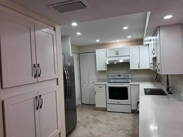 a kitchen with stainless steel appliances granite countertop a refrigerator and a sink