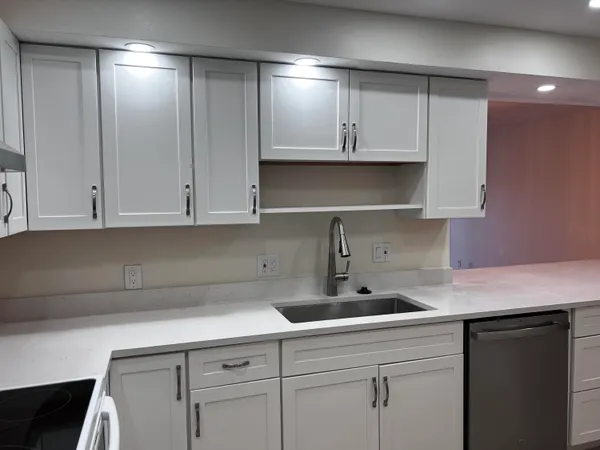 a kitchen with white cabinets and a sink