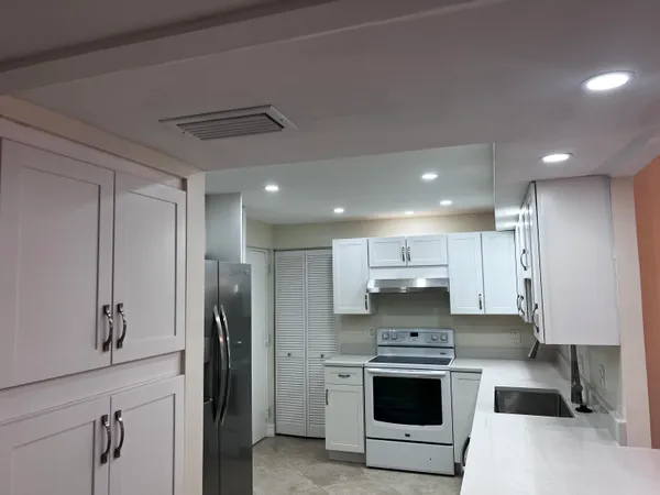a large kitchen with a stove and a refrigerator