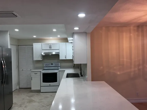 a kitchen with stainless steel appliances a stove a sink and a refrigerator