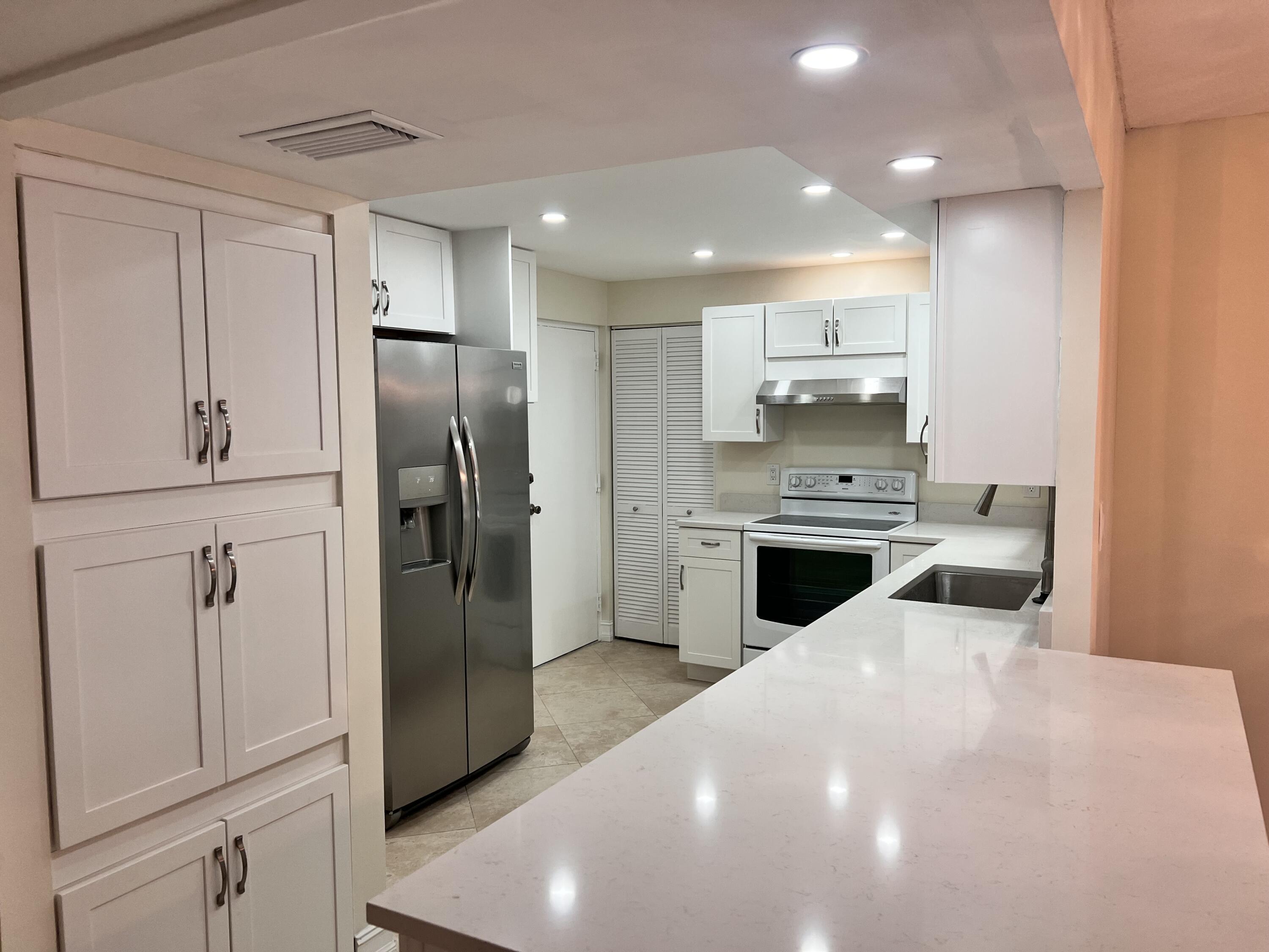 6000 Northwest 2nd Avenue, Unit 439 Boca Raton, FL 33487 - Photo 8 of 12 a kitchen with a refrigerator sink and cabinets