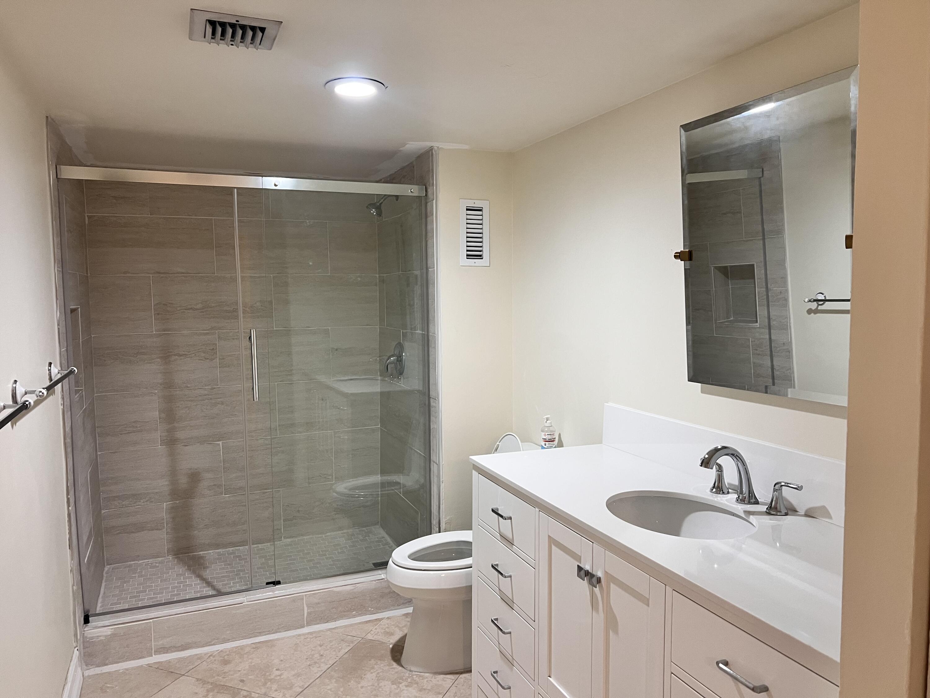 6000 Northwest 2nd Avenue, Unit 439 Boca Raton, FL 33487 - Photo 10 of 12 a bathroom with a granite countertop sink a toilet and shower