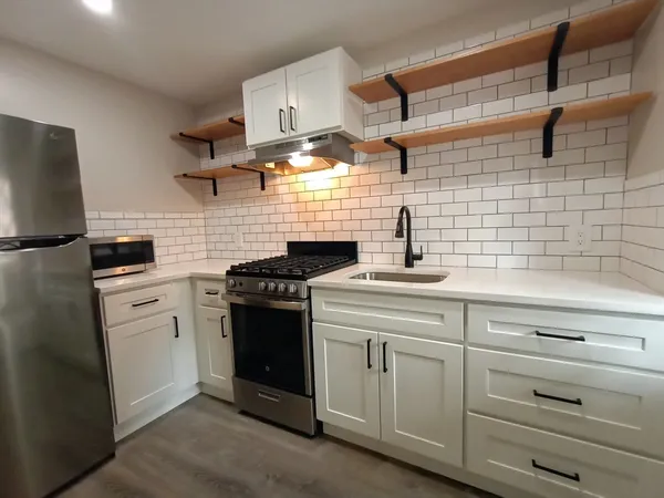 a kitchen with white cabinets and appliances