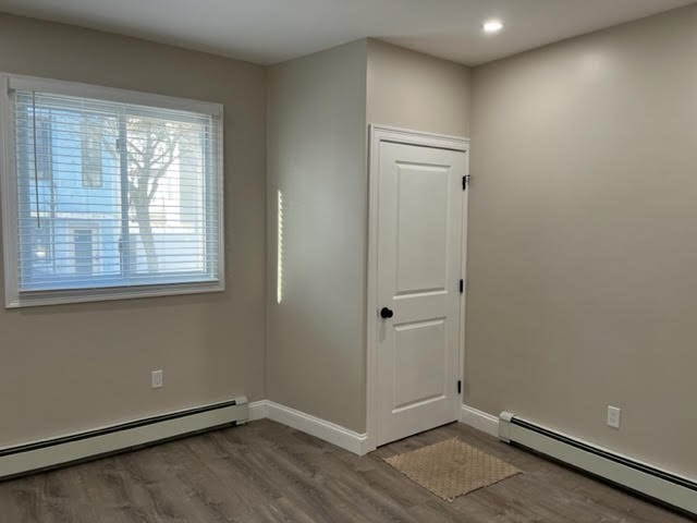 95 Cottage Street, Unit A Boston, MA 02128 - Photo 12 of 18 a view of an empty room with wooden floor and a window