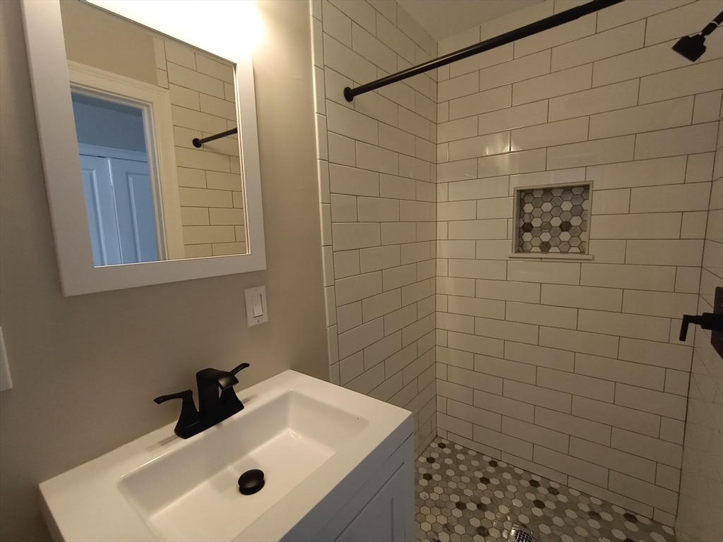 95 Cottage Street, Unit A Boston, MA 02128 - Photo 17 of 18 a bathroom with a sink a toilet and shower
