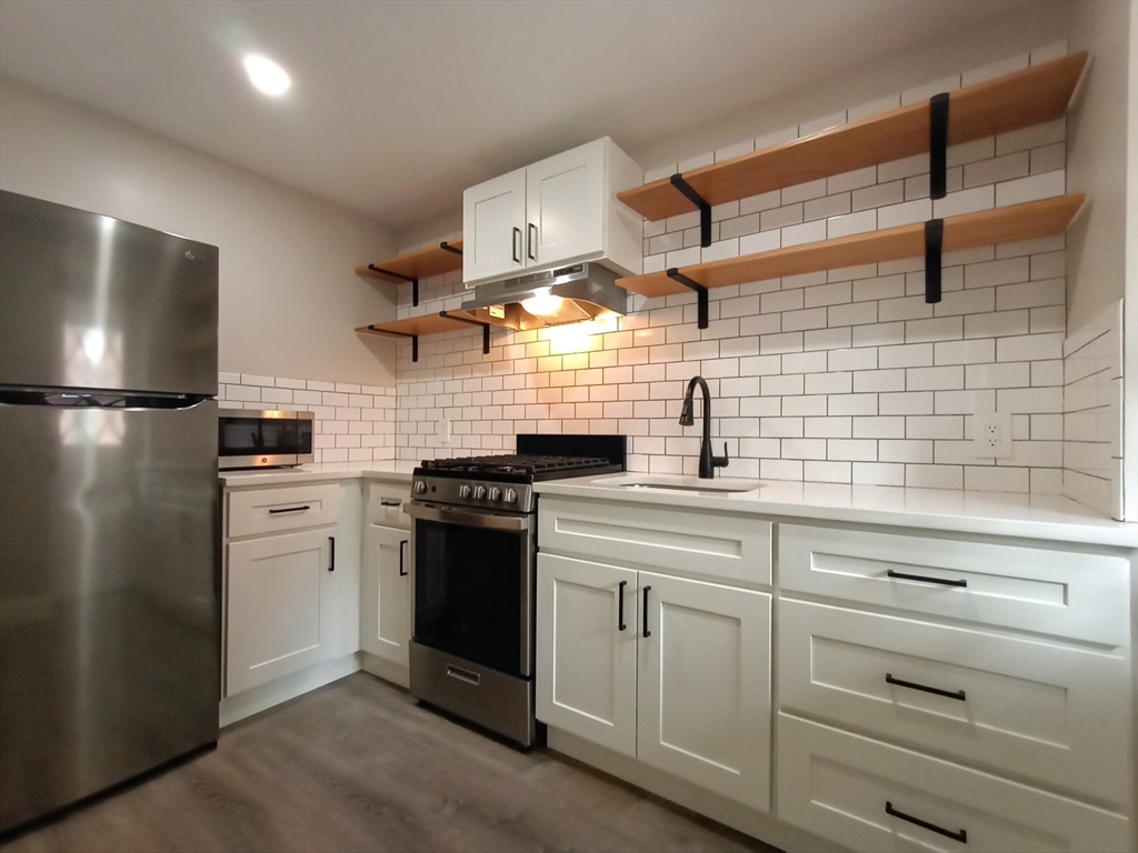 95 Cottage Street, Unit A Boston, MA 02128 - Photo 2 of 18 a kitchen with cabinets and stainless steel appliances