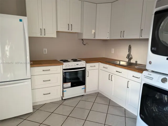 a kitchen with white cabinets and white appliances