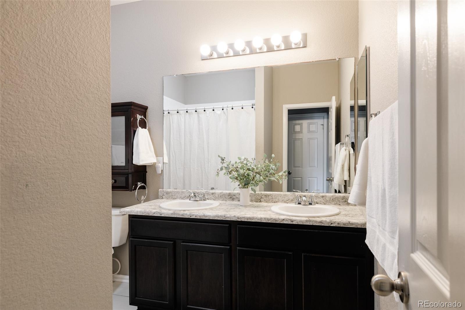 220 South Ider Way Aurora, CO 80018 - Photo 20 of 28 a bathroom with a sink and a mirror