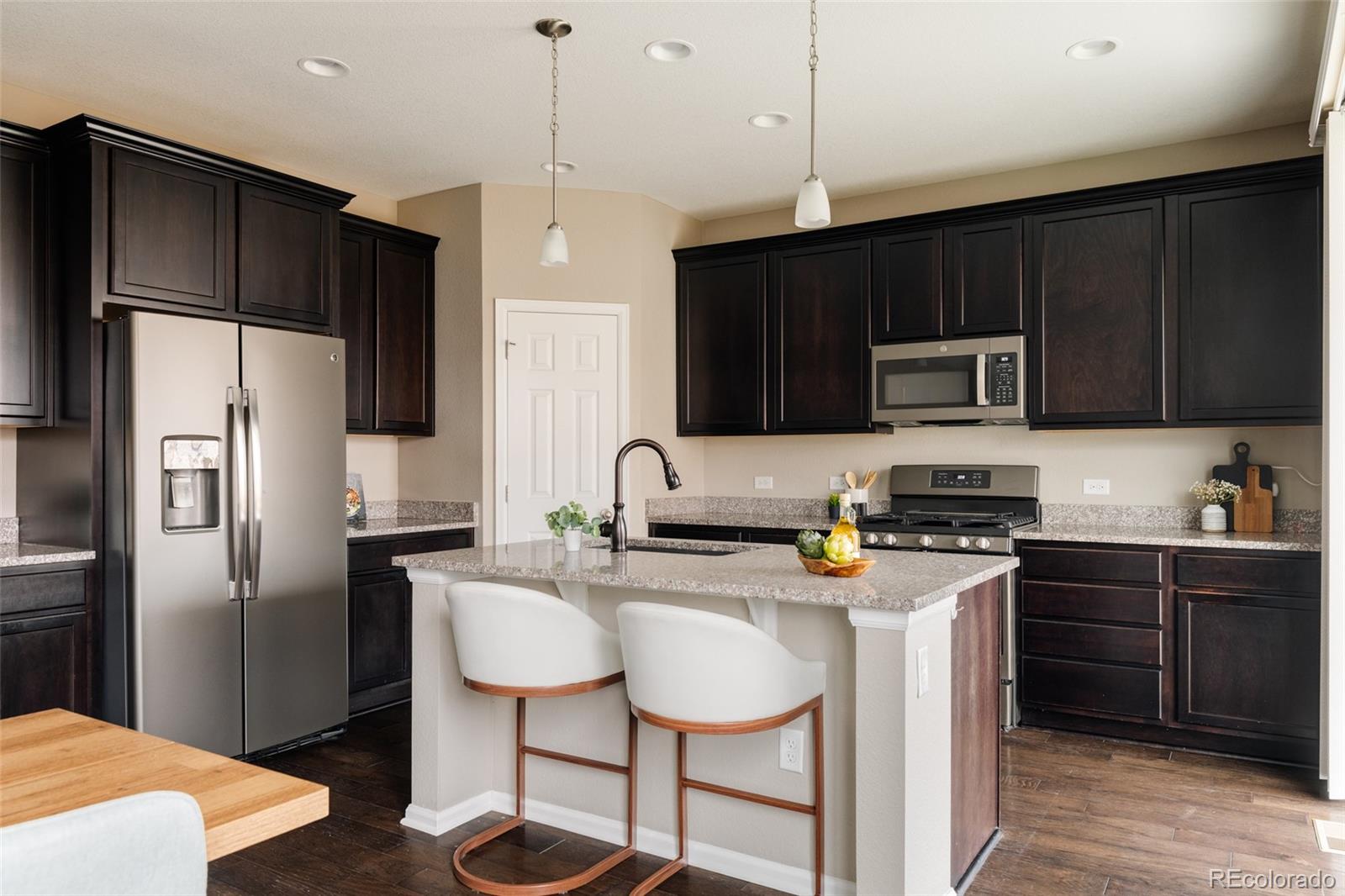 220 South Ider Way Aurora, CO 80018 - Photo 6 of 28 a kitchen with stainless steel appliances a stove a sink refrigerator and a wooden cabinets