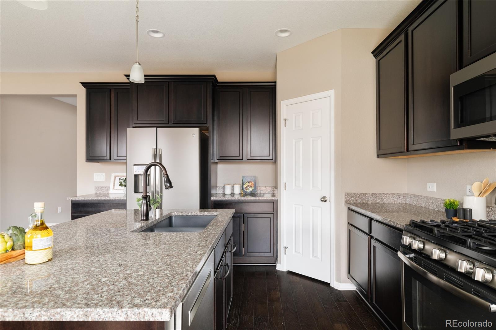 220 South Ider Way Aurora, CO 80018 - Photo 7 of 28 a kitchen with granite countertop a sink a stove and refrigerator