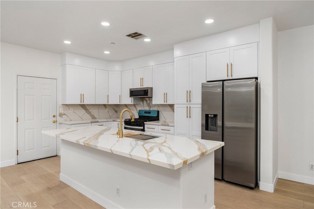 312 Quail Ridge Irvine, CA 92603 - Photo 11 of 21 a kitchen with kitchen island a refrigerator sink stove and microwave