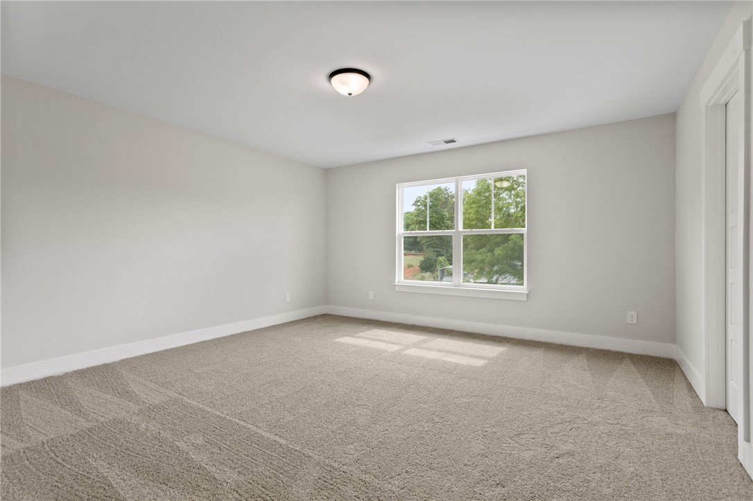 313 Old Shirley Road Central, SC 29630 - Photo 18 of 30 This airy bedroom offers a serene retreat with natural light and soft, neutral carpeting.