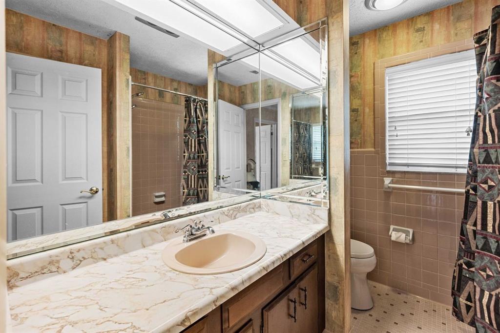 38730 Mickler Road Dade City, FL 33523 - Photo 16 of 38 a bathroom with a granite countertop sink and a mirror