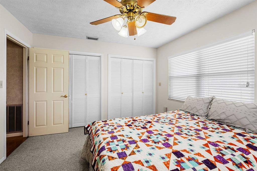 38730 Mickler Road Dade City, FL 33523 - Photo 18 of 38 a bedroom with a bed and a chandelier