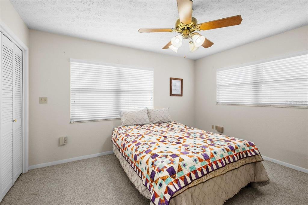 38730 Mickler Road Dade City, FL 33523 - Photo 19 of 38 a bedroom with a bed and a chandelier
