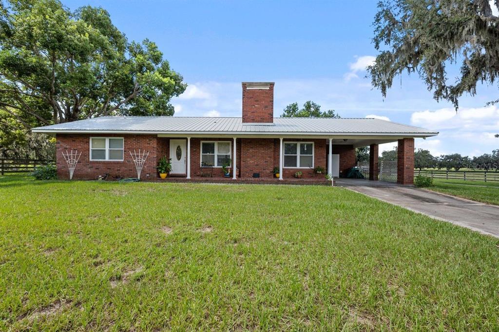 38730 Mickler Road Dade City, FL 33523 - Photo 38 of 38 a view of house with a yard and potted plants