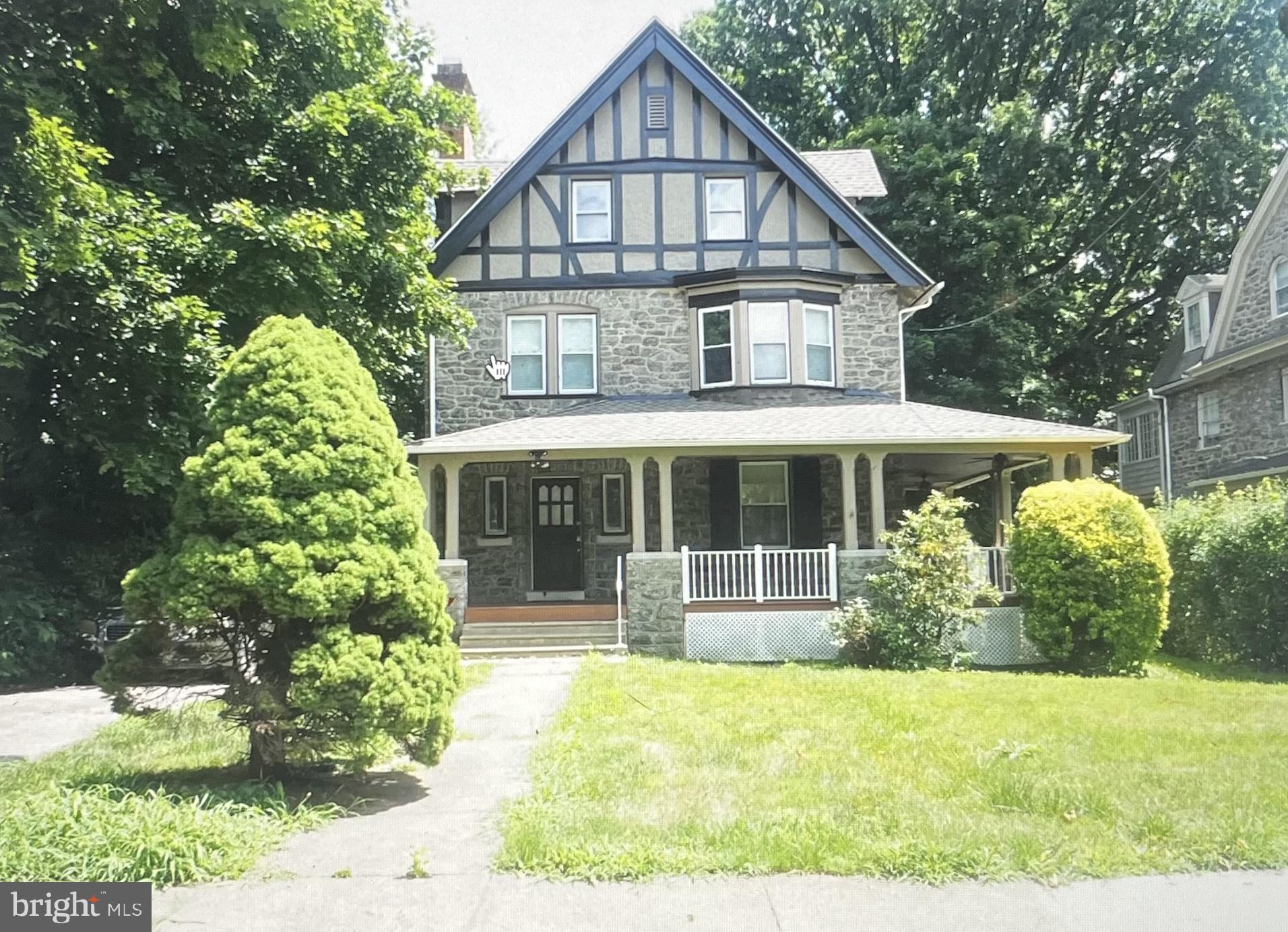a front view of a house with a yard and potted plants