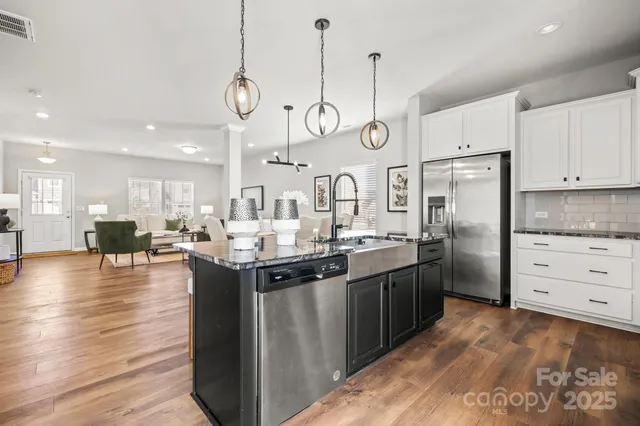 a kitchen with granite countertop white cabinets and stainless steel appliances