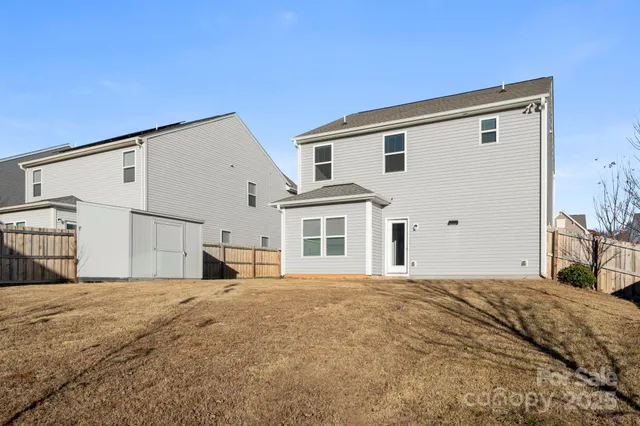 a view of a white house with large windows next to a road