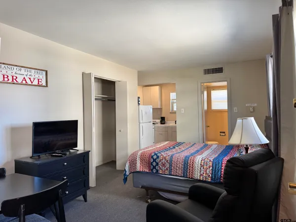 a bedroom with a bed and a flat screen tv