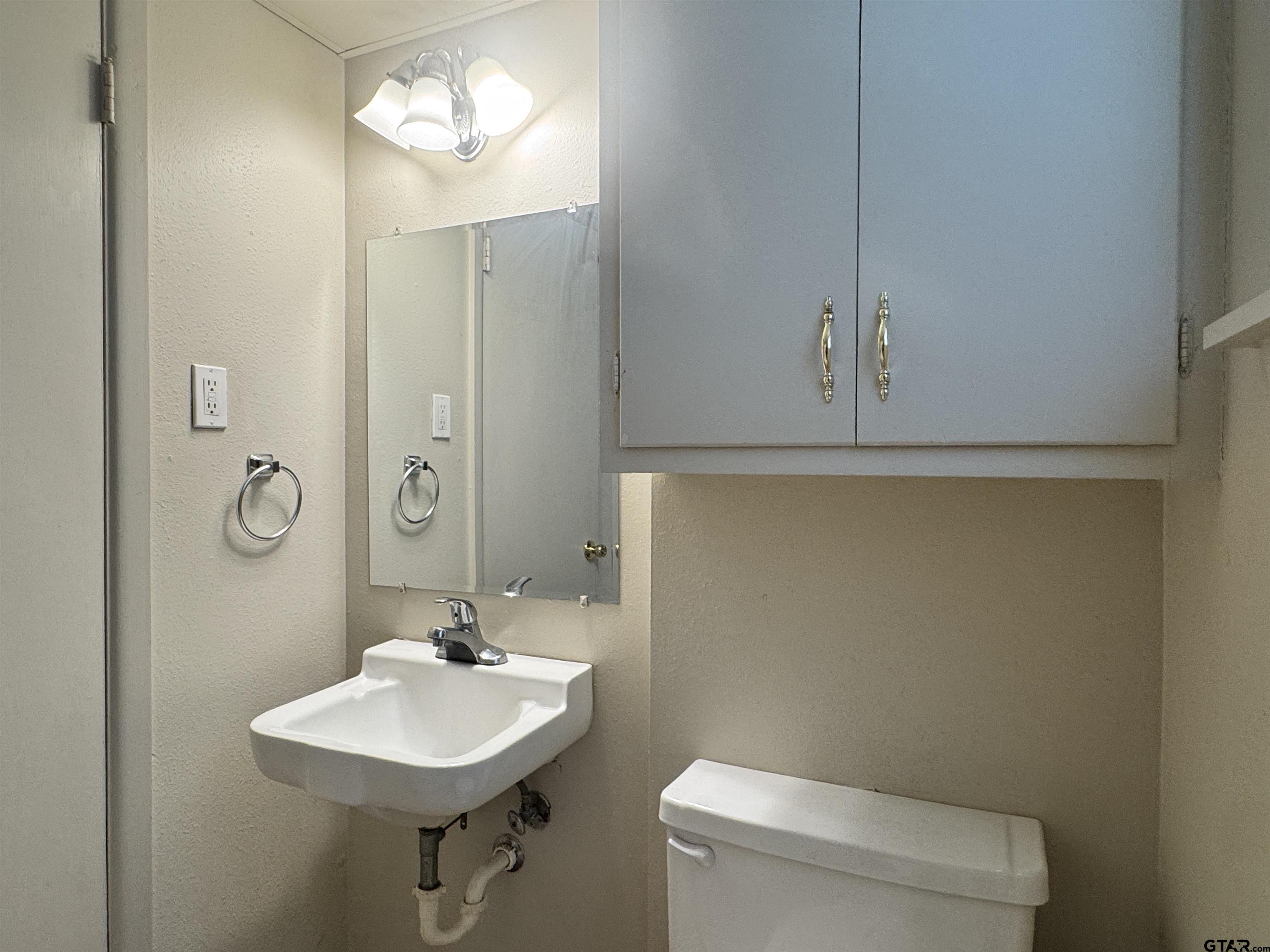 528 South Saunders Avenue Tyler, TX 75702 - Photo 8 of 11 a bathroom with a sink a toilet and mirror